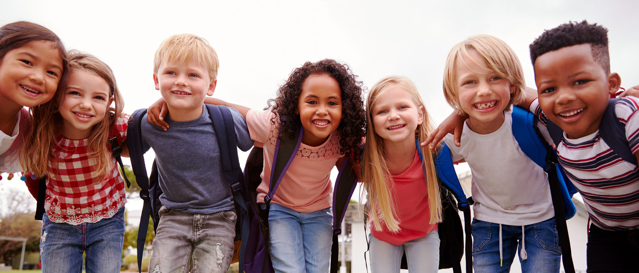 Portrait Of Excited Elementary School Pupils On Playing Field At Break Time